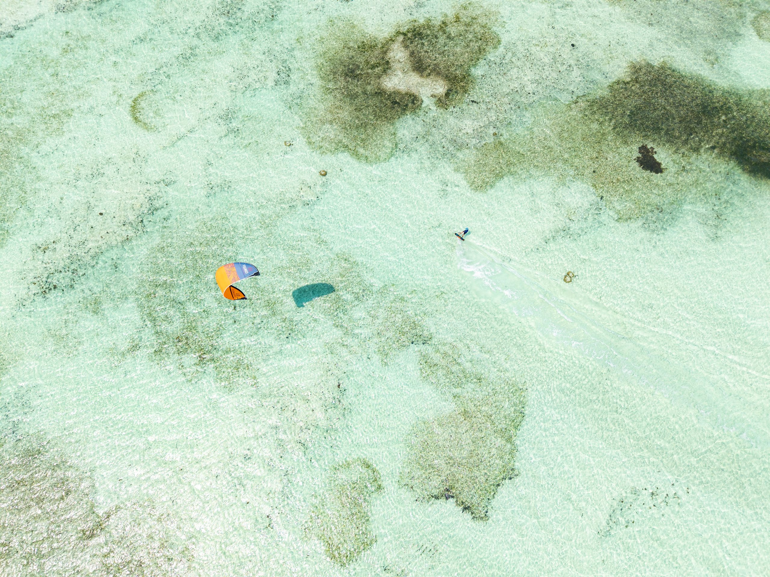 Aerial view of a kitesurfer on the shallow turquoise lagoon off Zanzibar